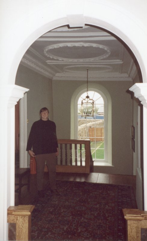 Deb on the landing, back garden through window