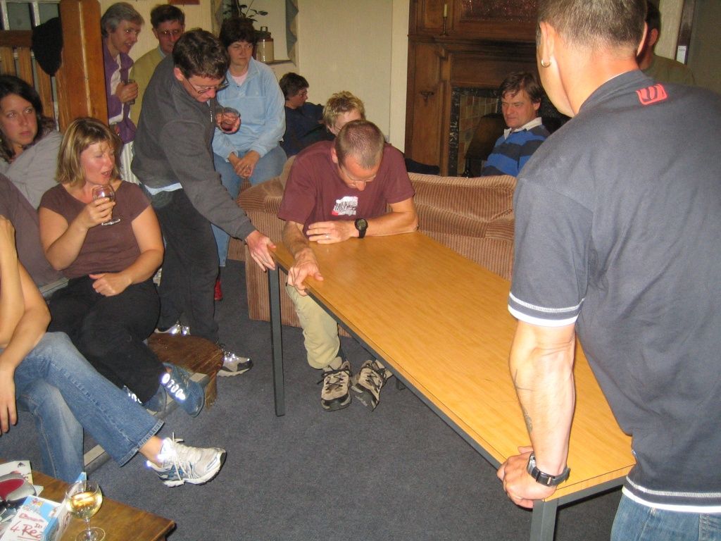 Justin climbing along/under the table, no feet on ground.